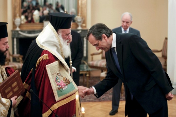 Newly appointed Greek Prime Minister Samaras bows in front of Greece's Orthodox Archbishop Ieronymos after a swearing in ceremony at the Presidential palace in Athens