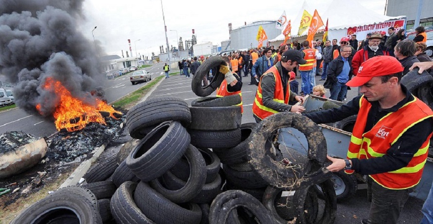 epa02399672 Workers on strike burn tires as they block the access of Total oil refinery in Donges, France, 18 October 2010. Many oil refineries and fuel depots have been blocked in France by demonstrators who oppose the government pension law, causing fuel shortages.  EPA/MAXPPP/FRANCK DUBRAY FRANCE OUT, BELGIUM OUT