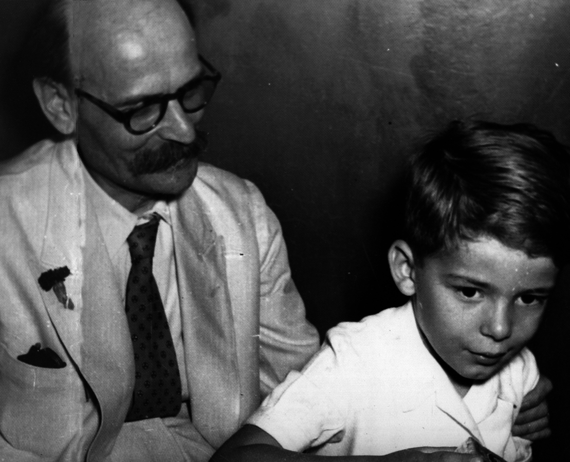 Ο Νίκος Πλουμπίδης με το γιό του Δημήτρη (σήμερα είναι καθηγητής Ψυχιατρικής στο Πανεπιστήμιο Αθηνών) στη διάρκεια της δίκης του. Το μικρό παιδί έβλεπε τον πατέρα του για πρώτη φορά αφού αυτός για πολλά χρόνια ζούσε στην παρανομία.