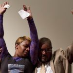 Lesley McSpadden, mother of Michael Brown, who was shot and killed on Saturday during a confrontation with the police in Ferguson, Mo., raises her arms with the Rev. Charles Ewing, Brown?s uncle, at a memorial service Tuesday night in Dellwood, Mo.