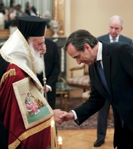 Newly appointed Greek Prime Minister Samaras bows in front of Greece’s Orthodox Archbishop Ieronymos after a swearing in ceremony at the Presidential palace in Athens