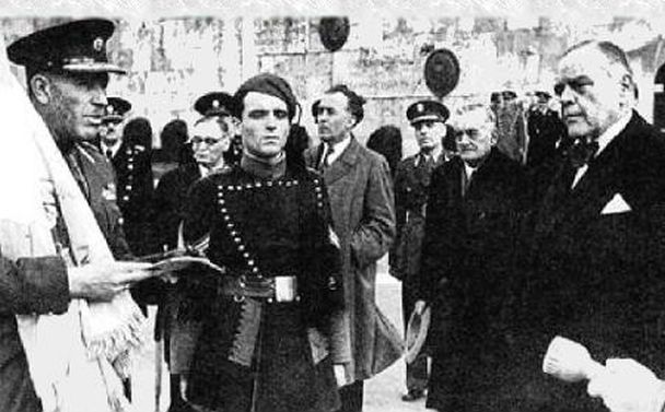 Ο Ιωάννης Ράλλης πρώην υπουργός της κυβέρνησης Γούναρη , συνελήφθη κι αυτός με διαταγή της Επαναστατικής Επιτροπής. Πρωθυπουργός στην τρίτη κατοχική κυβέρνηση των δοσιλόγων, συνεργατών των ναζί κατακτητών, ήταν ο δημιουργός των προδοτικών Ταγμάτων Ασφαλείας. Δικάστηκε μετά την Απελευθέρωση σε ισόβια δεσμά. Πέθανε το 1946 στη φυλακή. Γιός του ήταν το κορυφαίο στέλεχος του αστικού καθεστώτος και πρωθυπουργός ,διάδοχος του Κωνσταντίνου Καραμανλή, Γεώργιος Ράλλης. Στη φωτογραφία του 1944 ο Ιωάννης Ράλλης στον Άγνωστο Στρατιώτη , παρουσία γερμανών αξιωματικών, παραδίδει τις σημαίες στους διοικητές των μόλις δημιουργημένων Ταγμάτων Ασφαλείας, το συνταγματάρχη Πλυτζανόπουλο και άλλους προδότες αξιωματικούς