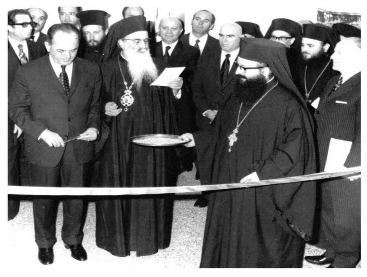 Από τελετή εγκαινίων στην περίοδο της χούντας. Δίπλα στο δικτάτορα Παπαδόπουλο, ο αρχιεπίσκοπος Ιερώνυμος Κοτσώνης, το δίσκο κρατάει ο νυν μητροπολίτης Θεσσαλονίκης, Άνθιμος, πίσω δεξιά διακρίνεται ο μετέπειτα αρχιεπίσκοπος Χριστόδουλος