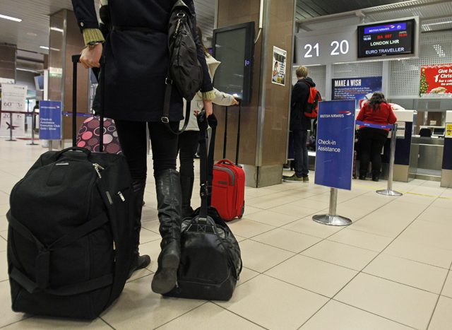 Romanians check in their luggage for a flight to Heathrow airport in Britain, at Otopeni international airport near Bucharest