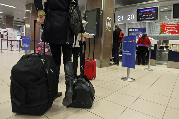 Romanians check in their luggage for a flight to Heathrow airport in Britain, at Otopeni international airport near Bucharest