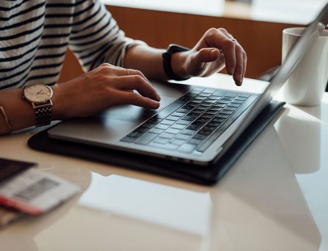person-seated-at-the-table-using-laptop