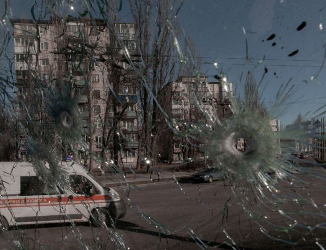 FILE PHOTO: An ambulance is seen through the damaged window of a vehicle hit by bullets in Kyiv