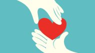 Close up of hand giving a red heart to another hand on green background