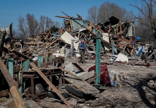 Local resident walks in a destroyed a village on the front line in the east Kyiv region