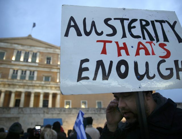 A protester displays his sign during an anti-austerity, pro-government demonstration outside the Greek parliament in Athens