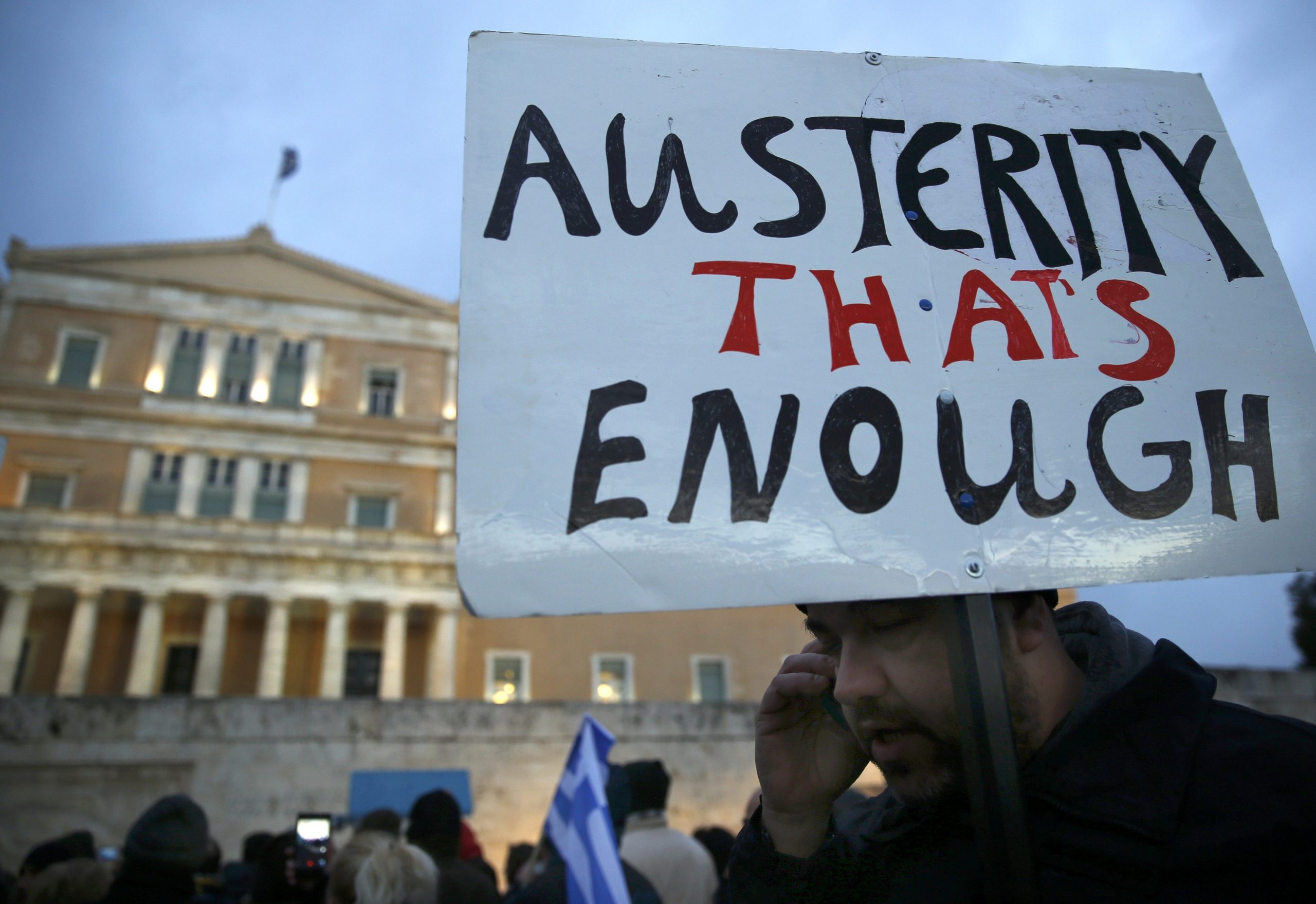 A protester displays his sign during an anti-austerity, pro-government demonstration outside the Greek parliament in Athens