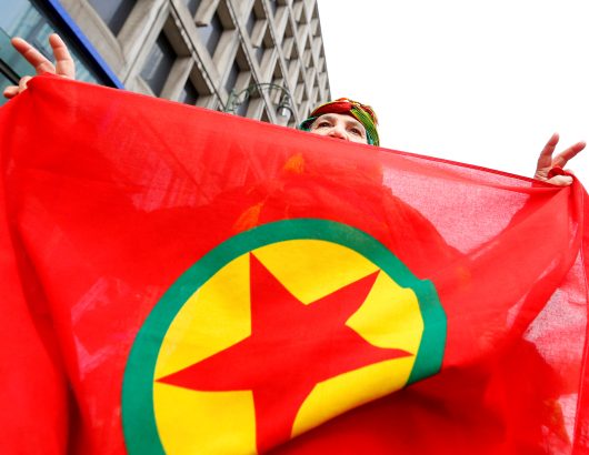 A woman holds a flag of the PKK during a demonstration against Turkish President Tayyip Erdogan in central Brussels
