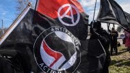 Members of the Great Lakes anti-fascist organization (Antifa) fly flags during a protest against the Alt-right outside a hotel in Warren, Michigan