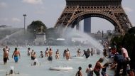People cool off in the Trocadero fountains across from the Eiffel Tower in Paris as a heatwave hit much of the country