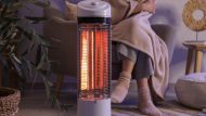 Young,Woman,With,Electric,Heater,And,Blanket,Sitting,On,Armchair